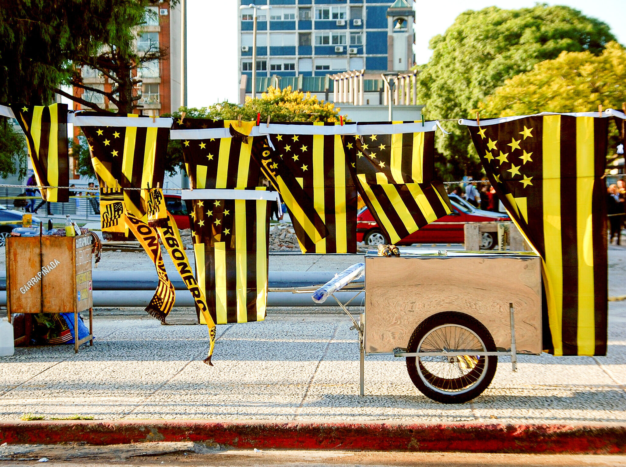 Uruguayan flag and Peñarol soccer club flags for sell on the street. Merchandising of Club Atlético Peñarol also known as carboneros. Flags for futbol enthusiast and fans for championship match.